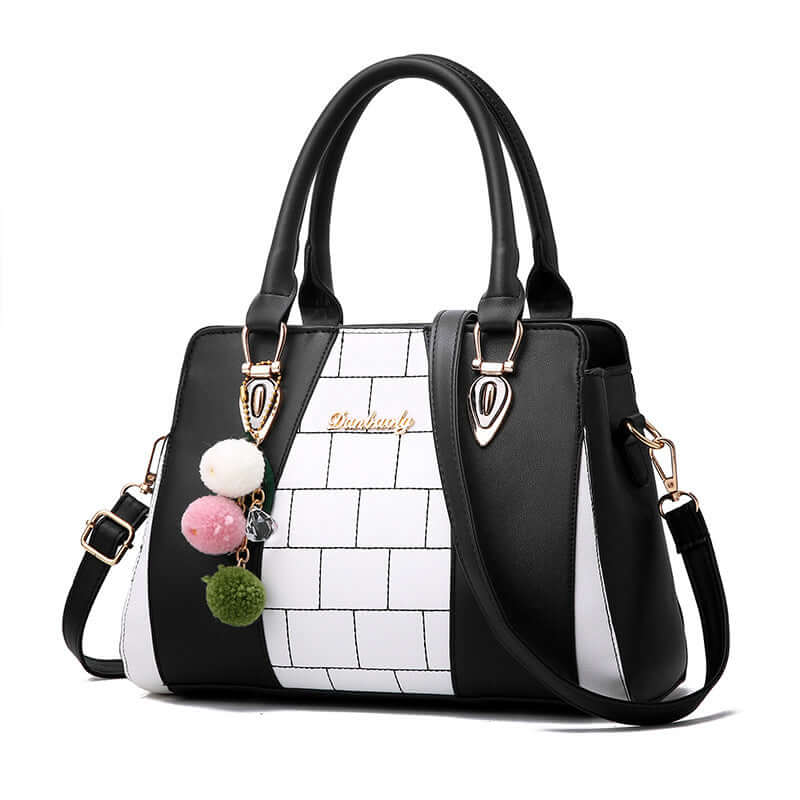 Stylish black and white shoulder bag for women with pom pom embellishments, perfect for everyday use.